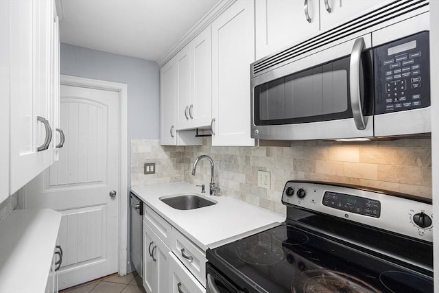 kitchen featuring tasteful backsplash, a sink, light countertops, white cabinets, and appliances with stainless steel finishes