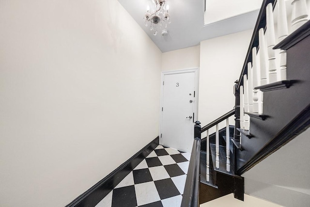 entrance foyer with stairway, tile patterned floors, baseboards, and an inviting chandelier