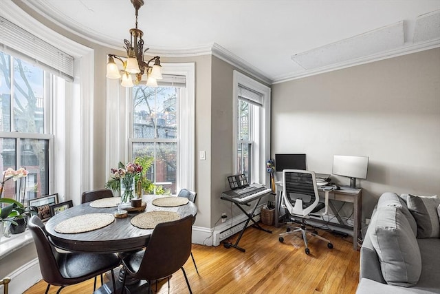 interior space featuring light wood finished floors, an inviting chandelier, crown molding, baseboards, and attic access