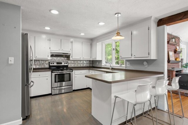 18 Arend Cir, Hanover, MA 02339 - kitchen featuring stainless steel appliances, under cabinet range hood, a peninsula, dark wood-type flooring, and tasteful backsplash