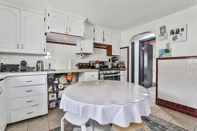 35 Linden Ter, Lynn, MA 01902 - kitchen featuring stainless steel gas stove, light tile patterned floors, white cabinetry, and light countertops