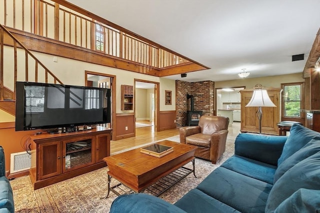 living room featuring a wood stove and a wainscoted wall