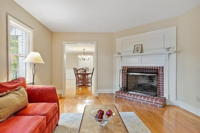 living room featuring wood finished floors, baseboards, and a fireplace