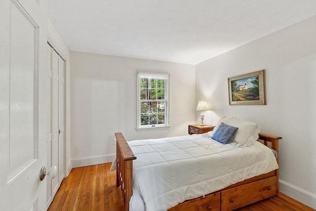 bedroom featuring baseboards, a closet, and light wood-type flooring