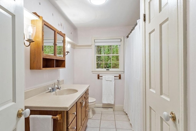 full bathroom featuring toilet, tile patterned flooring, vanity, and baseboards