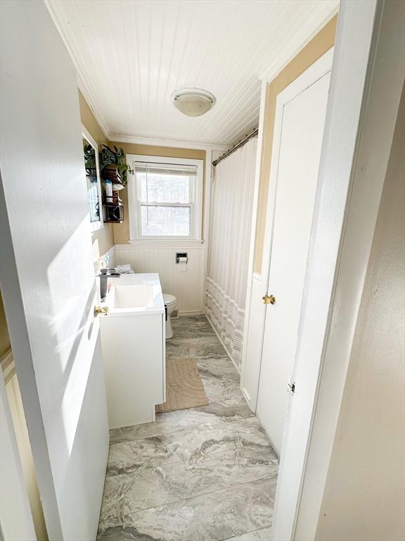 bathroom featuring vanity, curtained shower, toilet, and crown molding