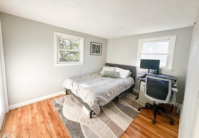 bedroom with multiple windows and wood-type flooring