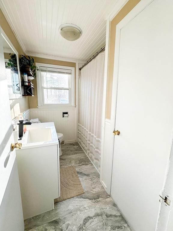 bathroom with vanity, toilet, ornamental molding, and walk in shower