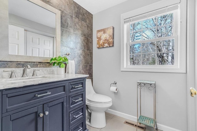 bathroom with vanity, visible vents, baseboards, tile patterned flooring, and toilet