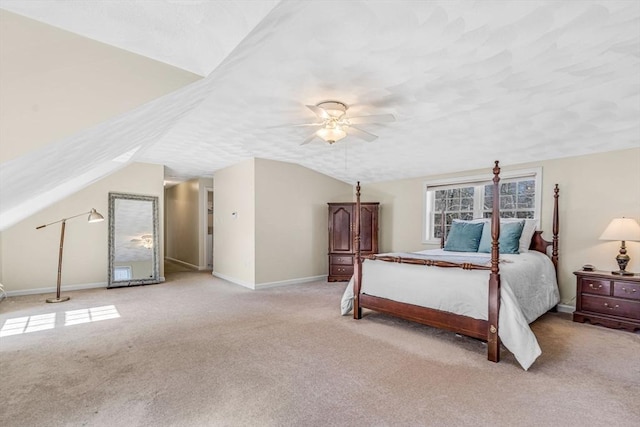 bedroom with ceiling fan, lofted ceiling, light colored carpet, and a textured ceiling