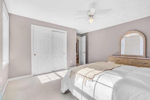 bedroom with ceiling fan, carpet, a closet, and baseboards