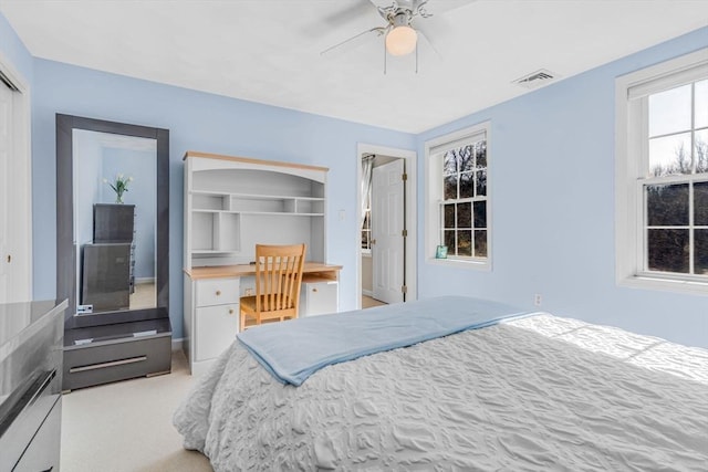 carpeted bedroom with visible vents, a closet, a ceiling fan, and built in study area