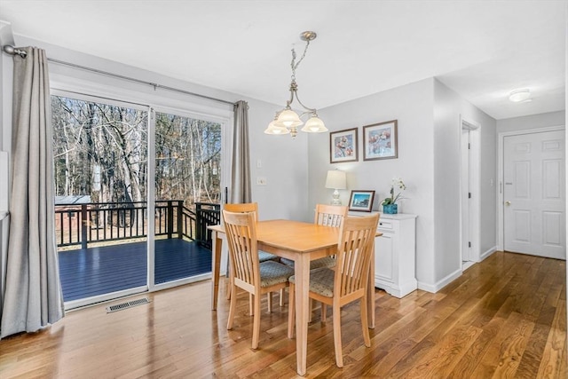 dining room with visible vents, baseboards, and wood finished floors