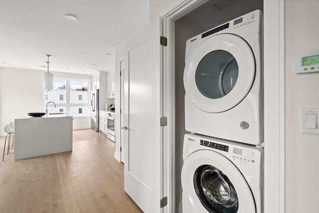 301 Border Unit 409, Boston, MA 02128 - washroom featuring stacked washer / drying machine and light wood-style floors