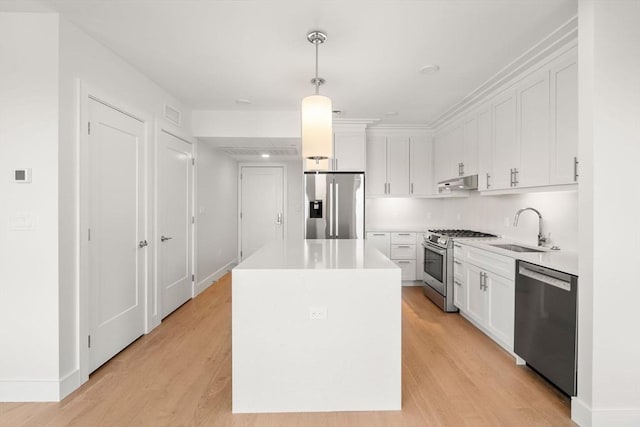 301 Border Unit 409, Boston, MA 02128 - kitchen featuring stainless steel appliances, a sink, under cabinet range hood, a kitchen island, and white cabinets