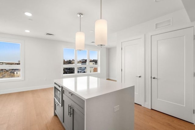 301 Border Unit 409, Boston, MA 02128 - kitchen with light wood-style flooring, healthy amount of natural light, gray cabinets, and recessed lighting
