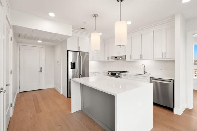 301 Border Unit 409, Boston, MA 02128 - kitchen featuring stainless steel appliances, a sink, under cabinet range hood, white cabinetry, and recessed lighting