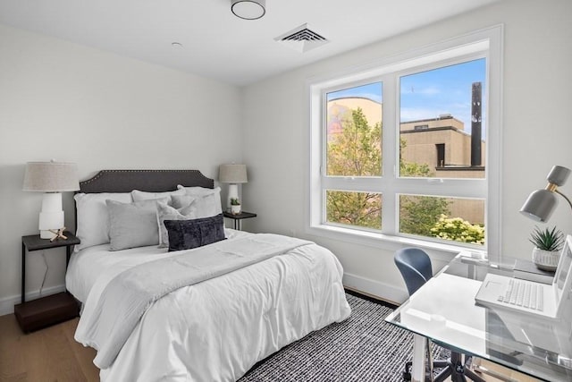 301 Border Unit 409, Boston, MA 02128 - bedroom with baseboards, multiple windows, wood finished floors, and a desk