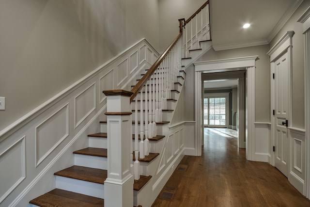 staircase with dark hardwood / wood-style flooring and crown molding