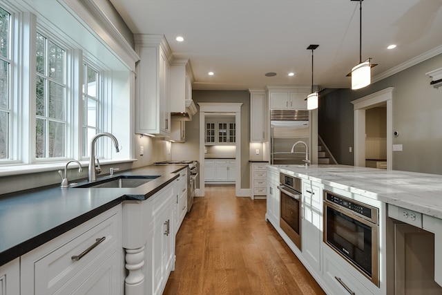 kitchen featuring white cabinets, pendant lighting, and premium appliances