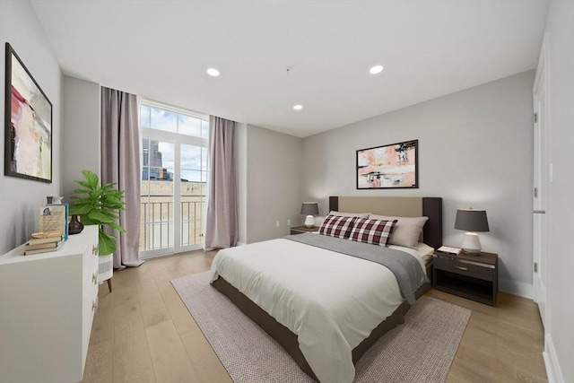 bedroom featuring access to outside, recessed lighting, light wood-style floors, and expansive windows