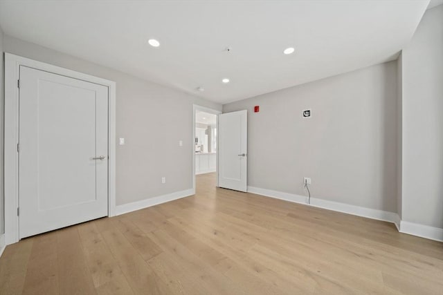 spare room with recessed lighting, baseboards, and light wood-style floors