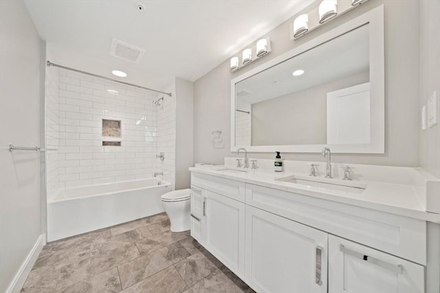 bathroom featuring double vanity, visible vents, toilet, and a sink