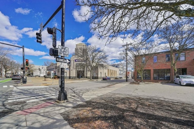 view of street featuring sidewalks, curbs, traffic signs, and traffic lights