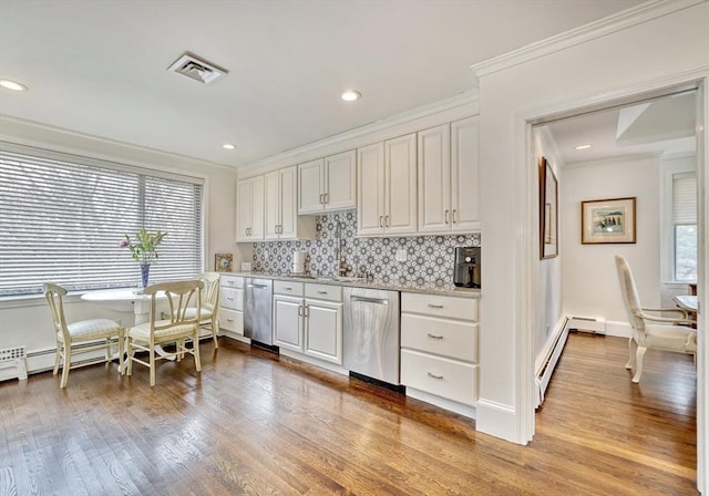 kitchen with visible vents, wood finished floors, stainless steel dishwasher, and ornamental molding