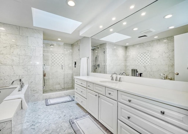 full bathroom featuring a skylight, a garden tub, recessed lighting, a shower stall, and vanity