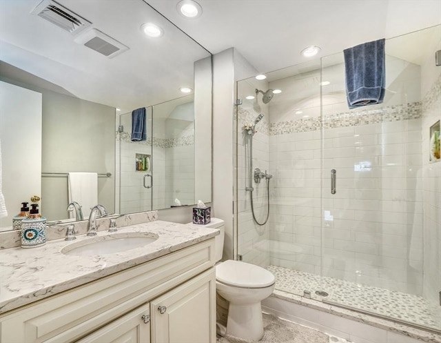 full bath featuring toilet, a shower stall, visible vents, and vanity