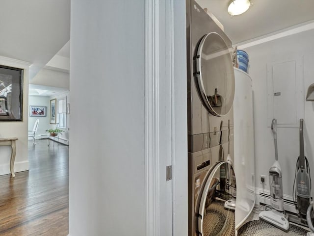 interior space with baseboards, stacked washing maching and dryer, and wood finished floors