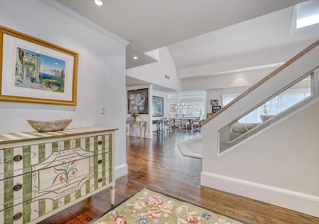 corridor with baseboards, lofted ceiling, wood finished floors, crown molding, and recessed lighting