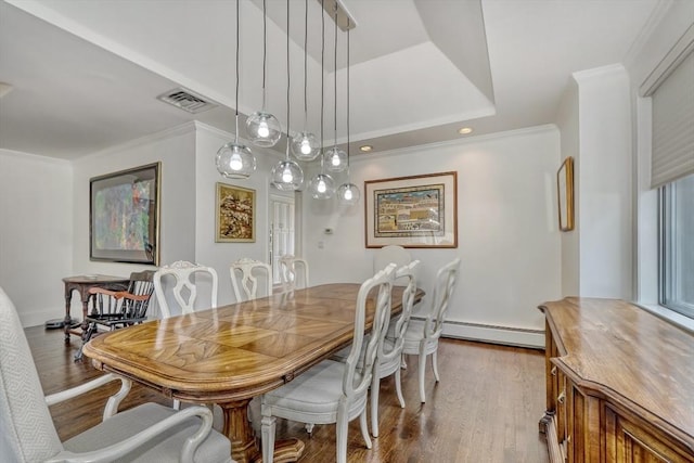 dining area featuring ornamental molding, wood finished floors, and visible vents