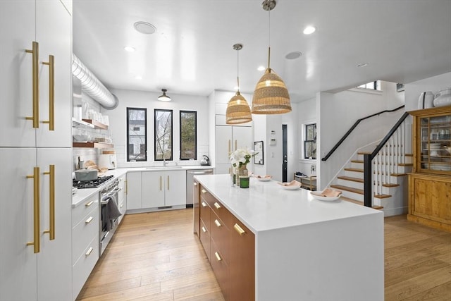 kitchen featuring light countertops, white cabinetry, and decorative light fixtures