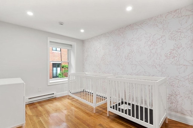 117 Fulton St Unit 4, Boston, MA 02109 - unfurnished bedroom featuring a baseboard radiator, wood finished floors, wallpapered walls, and recessed lighting