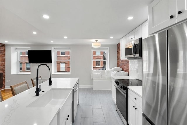 117 Fulton St Unit 4, Boston, MA 02109 - kitchen with stainless steel appliances, healthy amount of natural light, tasteful backsplash, white cabinets, and recessed lighting