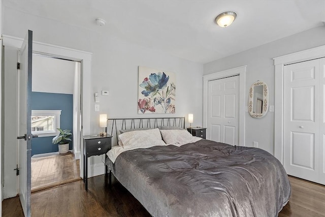 bedroom with hardwood / wood-style flooring and two closets