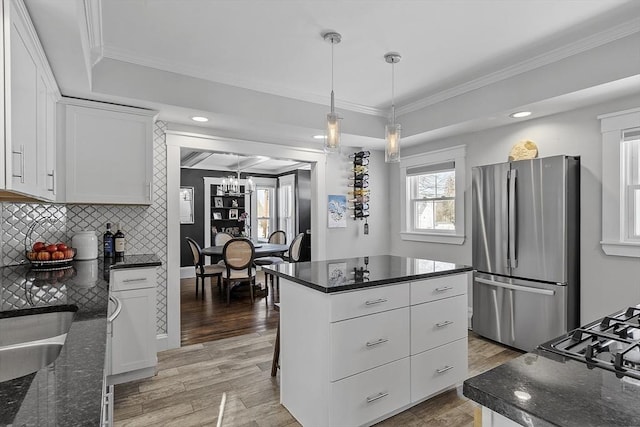 kitchen featuring white cabinetry, ornamental molding, pendant lighting, and stainless steel fridge