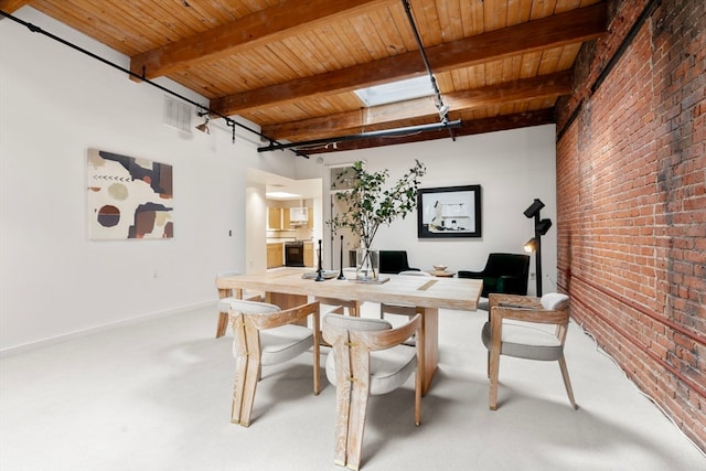 dining space with a skylight, carpet, beam ceiling, wood ceiling, and brick wall