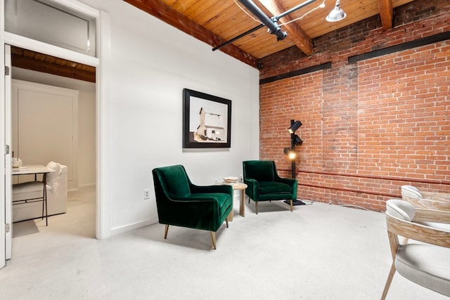 sitting room with wood ceiling, brick wall, and beamed ceiling