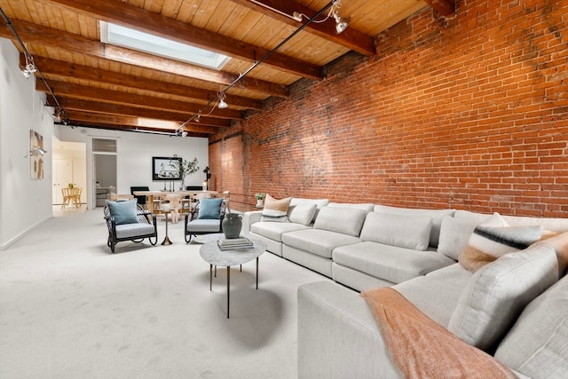 living room featuring beamed ceiling, wooden ceiling, brick wall, a skylight, and carpet flooring