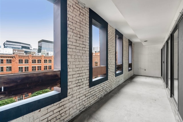 corridor featuring brick wall and concrete flooring