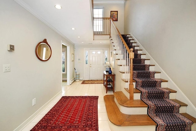 tiled entryway featuring ornamental molding, recessed lighting, baseboards, and stairs