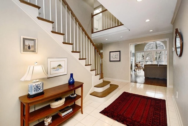 foyer entrance with crown molding, baseboards, and tile patterned floors