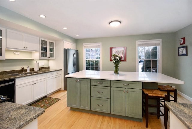 kitchen featuring green cabinets, a sink, white cabinetry, and dishwasher