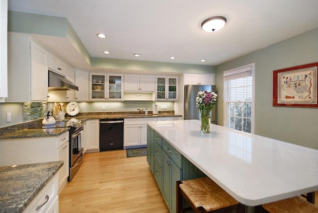 kitchen featuring stainless steel appliances, light wood-style floors, white cabinetry, and under cabinet range hood