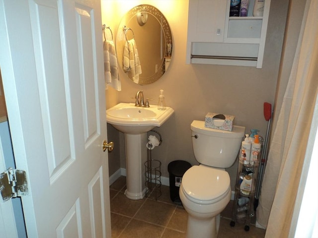 full bathroom featuring toilet, baseboards, tile patterned floors, and a sink