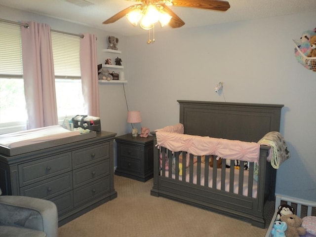 bedroom featuring light carpet and a ceiling fan
