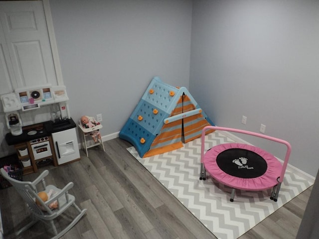 recreation room with wood finished floors and baseboards
